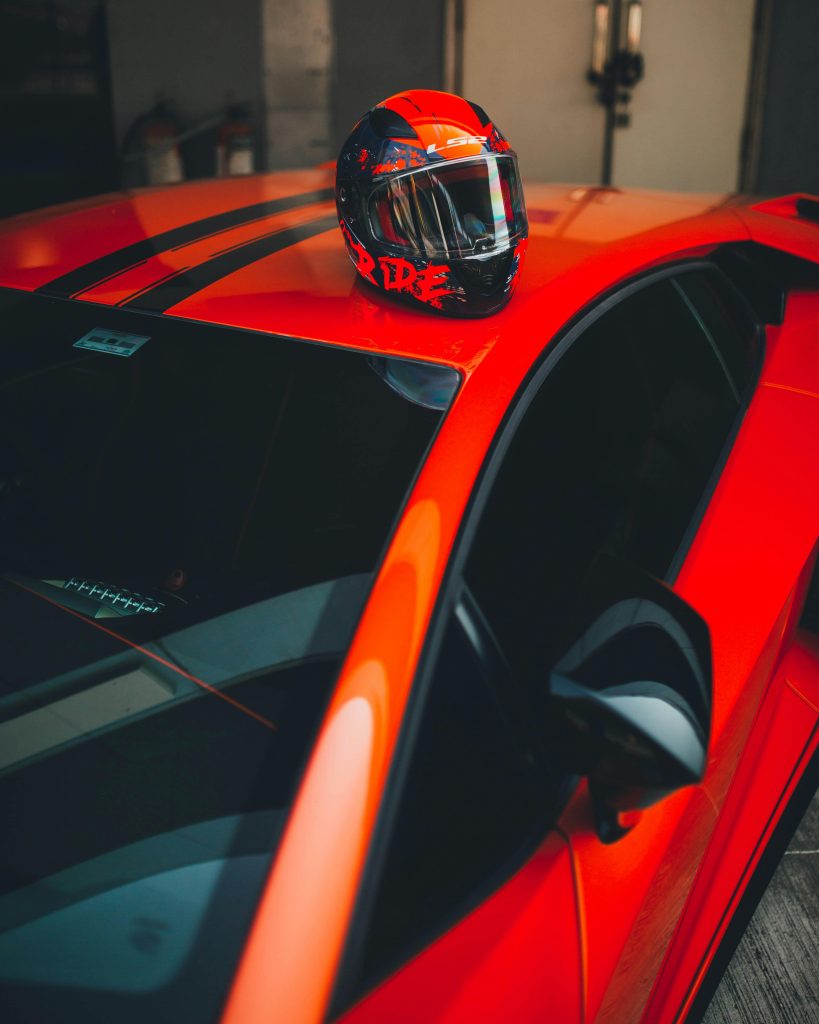 Dynamic shot of a red sports car with a racing helmet, symbolizing speed and adventure.
